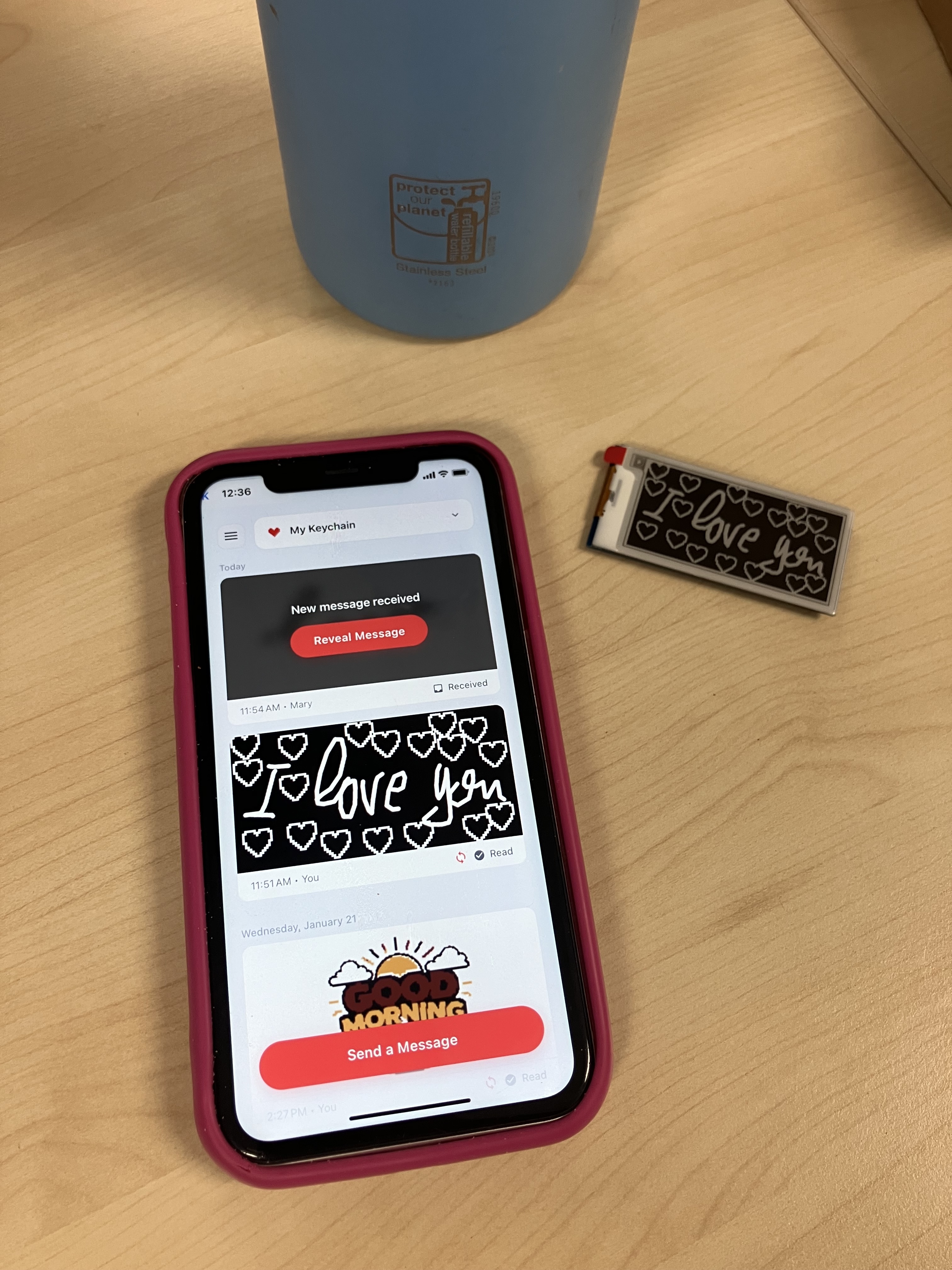 The KEEP proof of concept on a desk — a bare electronic board wired to a small e-ink screen, next to a phone running the KEEP app.